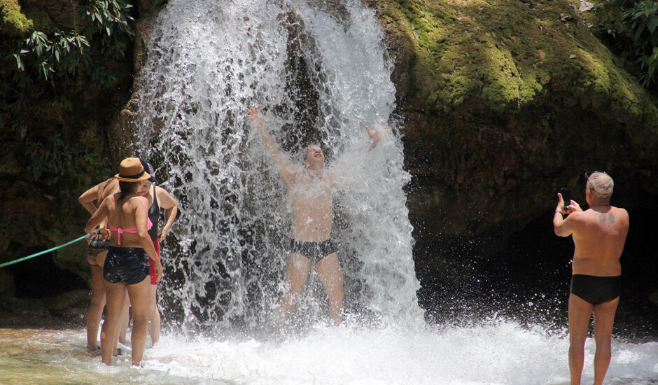 Turistas aproveitam cachoeira
