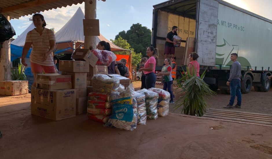 Voluntários levando as doações para caminhão no CTG Farroupilha