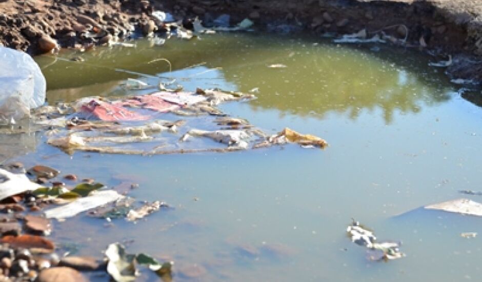Buraco cheio de água e lixo na Vila Piloto II, propício para a proliferação do mosquito da dengue