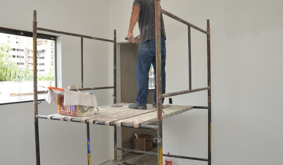Pintor de paredes trabalha em imóvel novo; autorizações de obras seguem ritmo da média de 2014