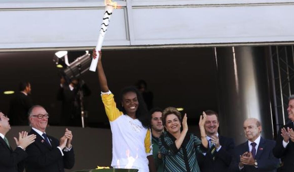A jogadora de vôlei Fabiana Claudino, bicampeã olímpica (2008 e 2012), recebe a Tocha Olímpica das mãos da presidenta Dilma. Presidenta diz que participantes serão bem recebidos no Brasil