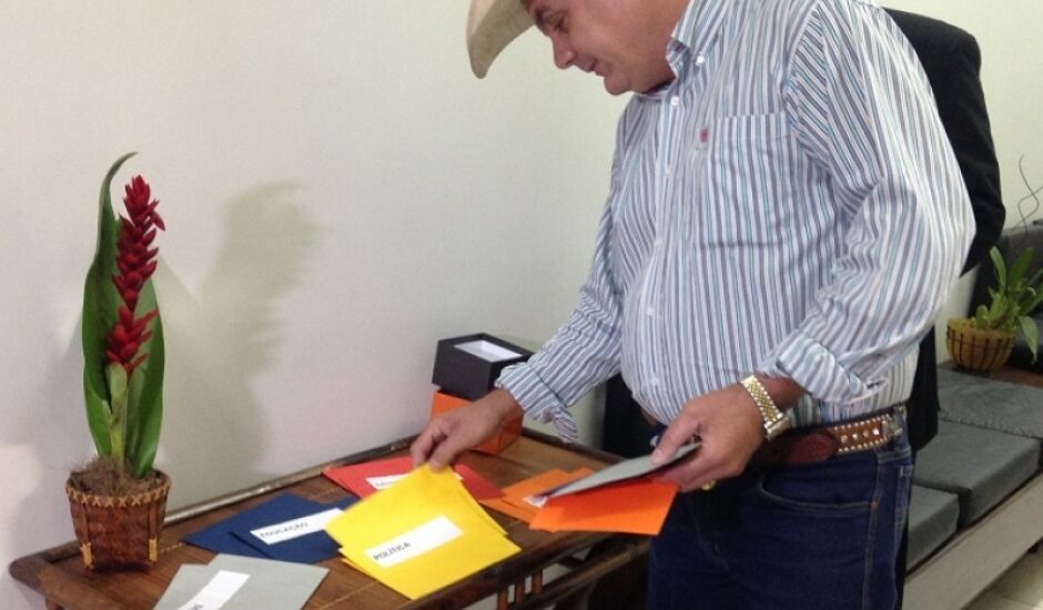 Ângelo Guerreiro escolhendo os envelopes lacrados com as perguntas dentro dos temas selecionados pela equipe de jornalismo da TVC