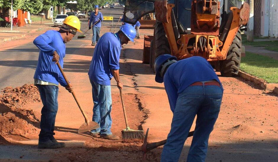 Trabalhadores tercerizados da Sanesul fecham valetas abertas para implantação de rede de esgoto.