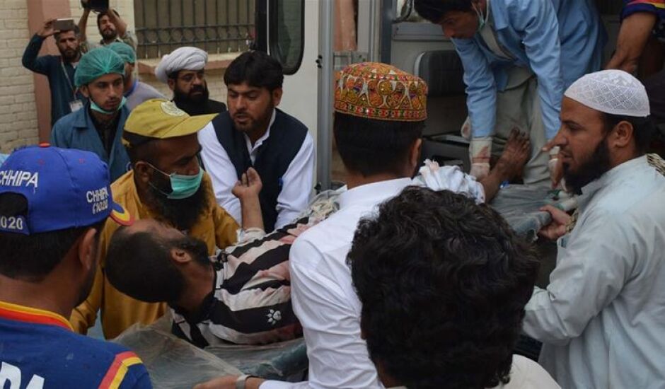 Voluntários paquistaneses se preparam para levar vítima de atentado ao hospital