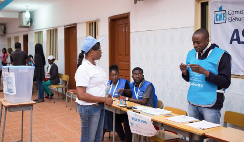 Integrante da Comissão Nacional Eleitoral confere documento de cidadã durante a votação em Luanda, Angola