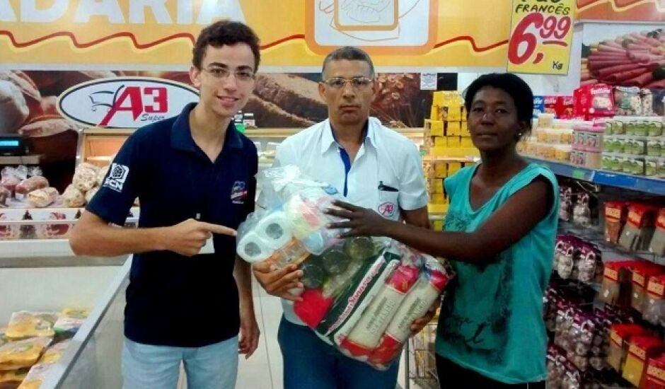 Locutor Alex Santos e equipe A3 Super entregam cesta básica a ganhadora da promoção Cesta da Sexta