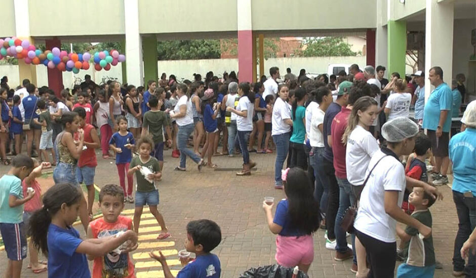 Crianças aguardam em fila, a distribuição de guloseimas e refrigerantes
