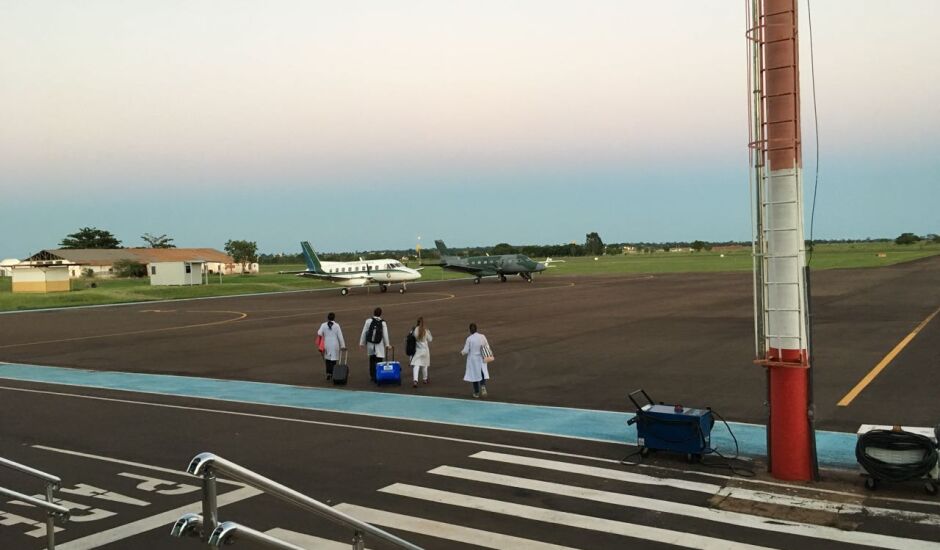 Equipes de médicos caminham para embarque nas aeropnaves, no final da manhã