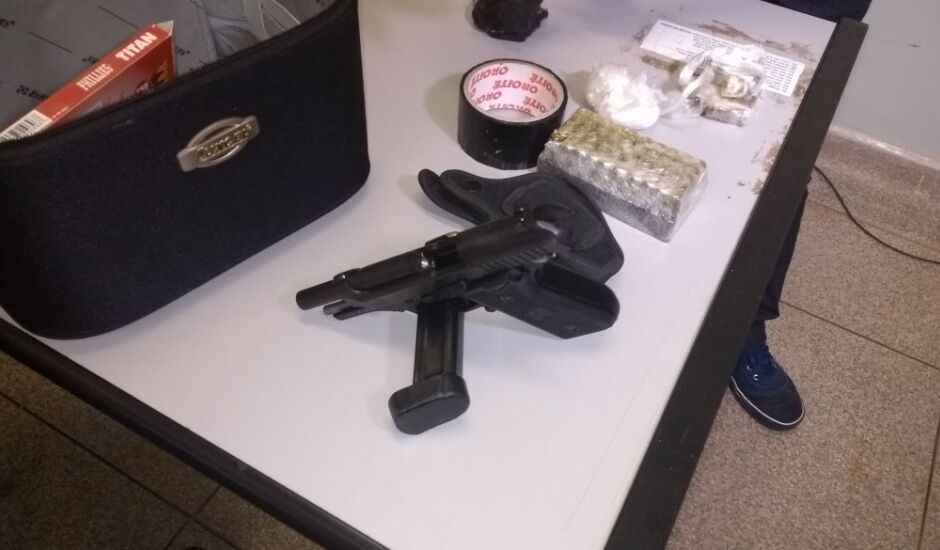 A arma, munições e drogas apreendidas na casa pela polícia