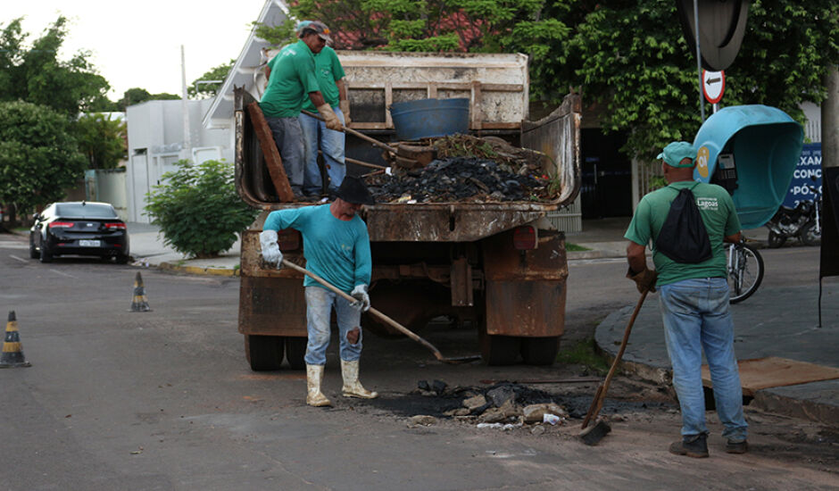 Trabalhadores em serviço de tapa-buraco em rua de Três Lagoas