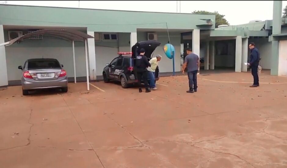 Walter Luís é retirado do carro da Polícia Civil, observado por investigadores, na quarta de manhã