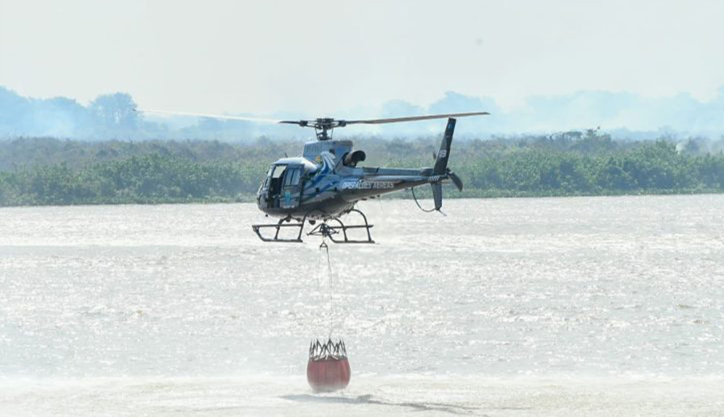 Helicóptero equipado com 'helibalde' atua no combate às chamas